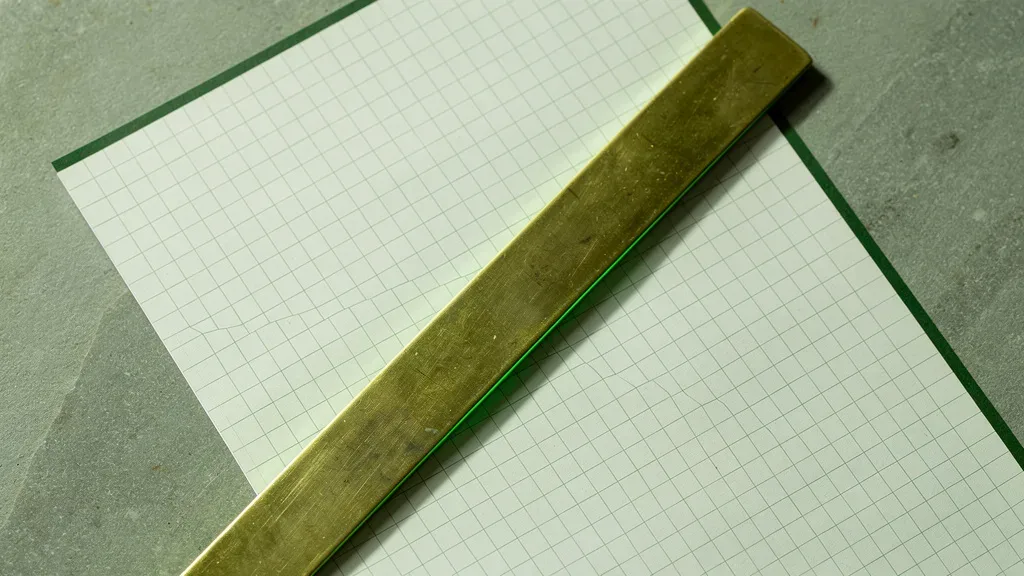 prazo de consórcio: régua metálica sobre papel milimetrado com marcações em escala, tonalidade verde nas bordas